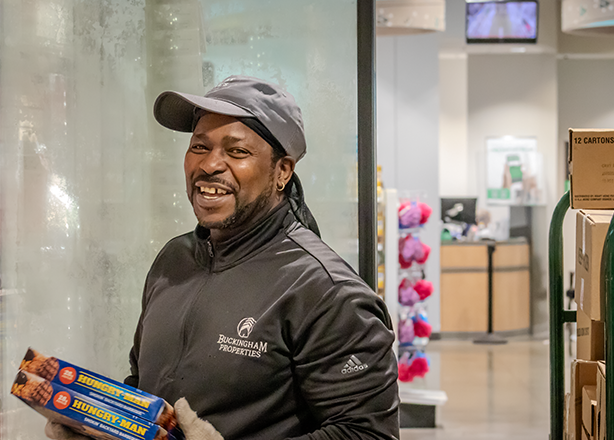 A man represented by UFCW Local 880, the grocery workers union in Cleveland, Ohio, smiles as he places items in a store freezer