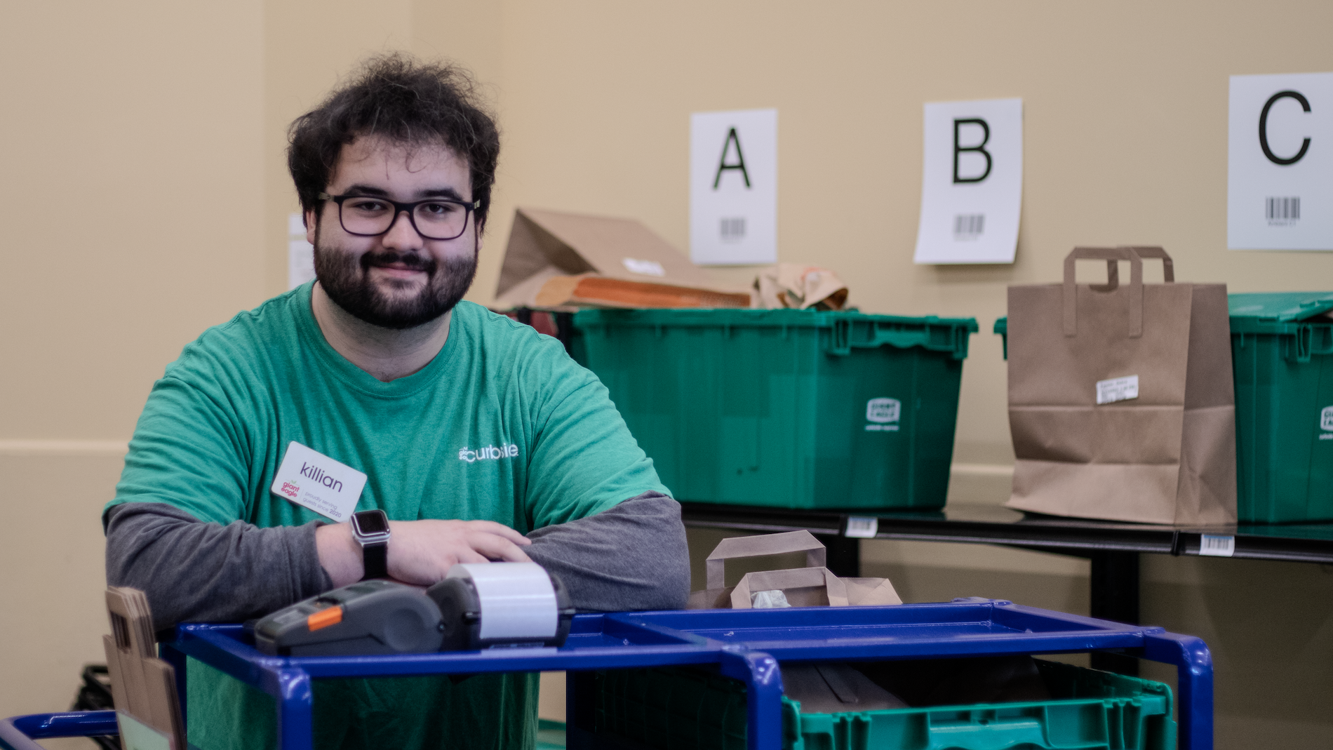 A smiling Giant Eagle employee represented by UFCW Local 880, the grocery workers union, prepares curbside pick-up grocery orders.