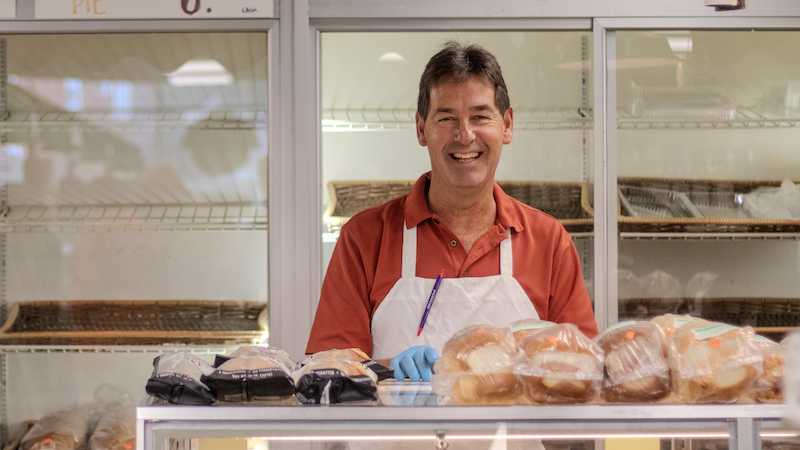 Smiling worker behind bread counter at grocery market in Cleveland, Ohio